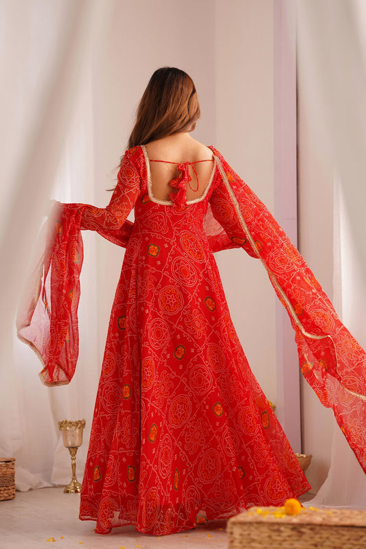 Back view of a woman wearing a flowing red Anarkali suit set with a dupatta, highlighting the graceful drape and bandhej print details