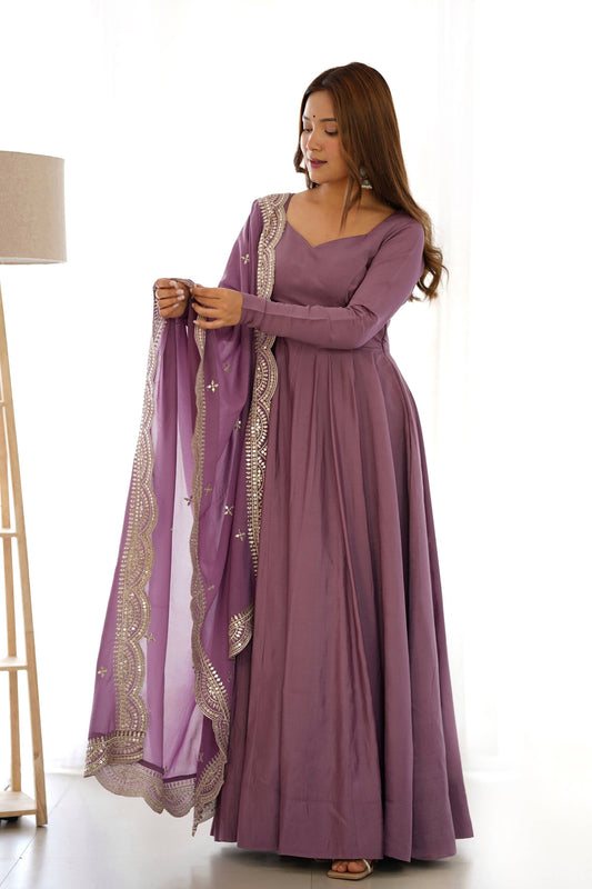 Woman wearing a long purple dress with a matching shawl on a white background