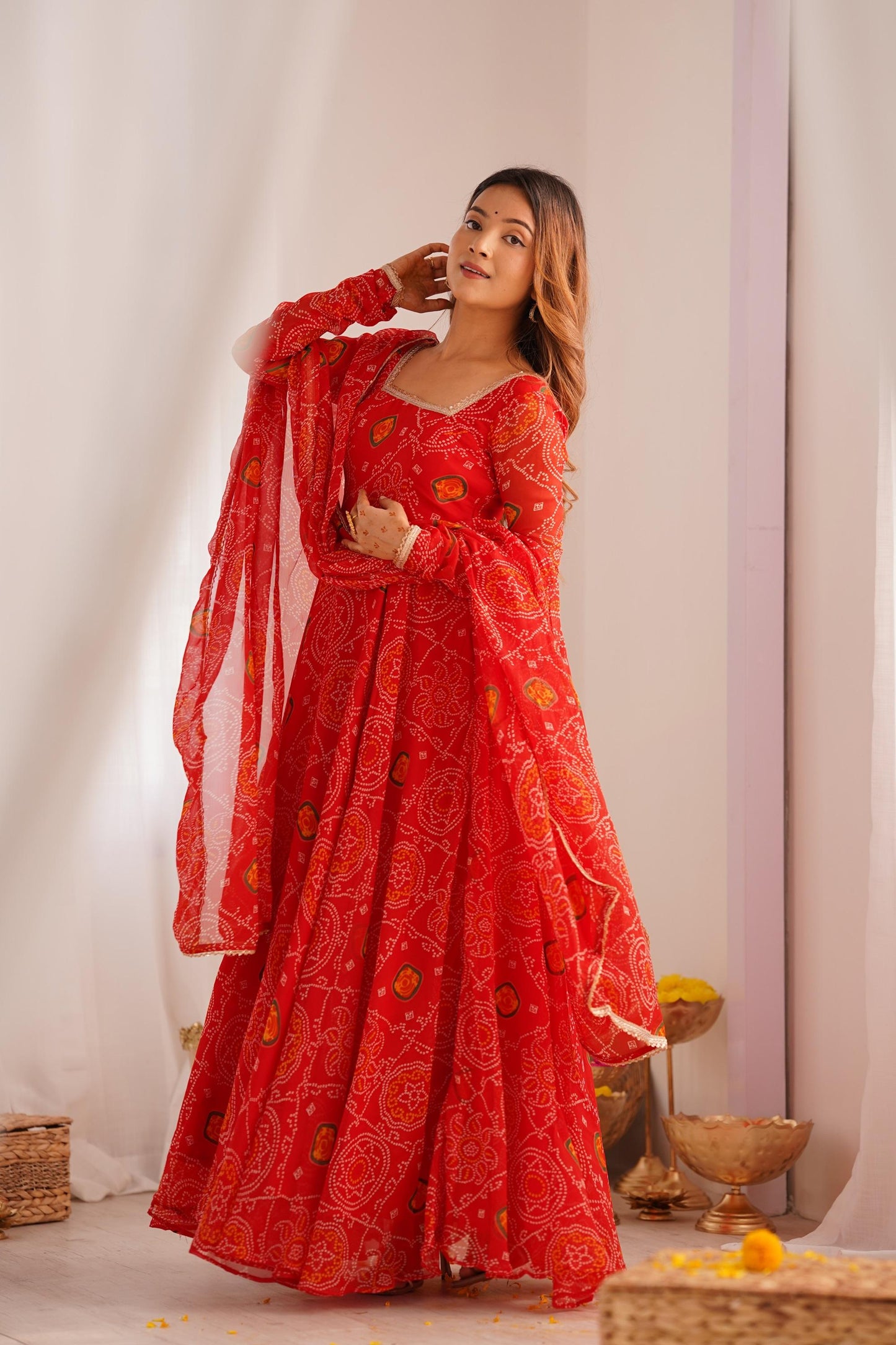 Side view of a woman wearing a flowing red Anarkali suit set with a dupatta, emphasizing the movement and the elegant silhouette